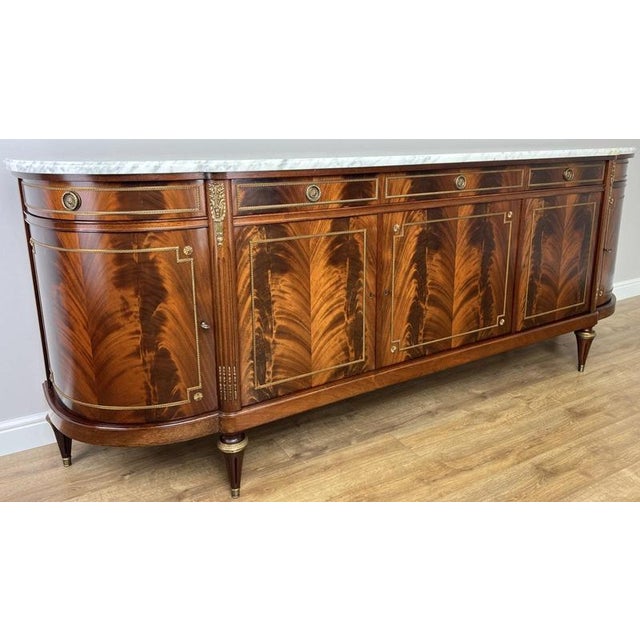 An exceptional vintage French Empire sideboard, beautifully designed with a striking marble top and rich decorative...