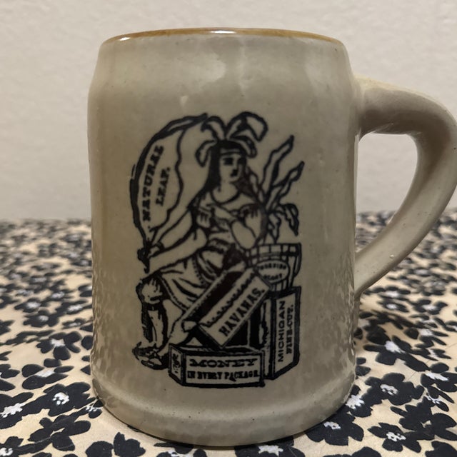 This vintage stoneware mug is a classic piece of American advertising pottery, specifically associated with Monmouth...