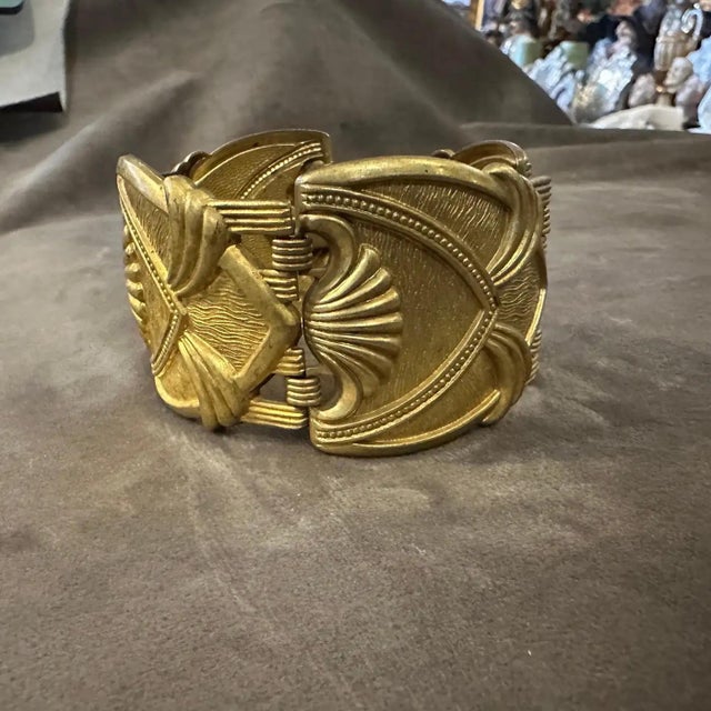 This 1930s Art Deco gilded metal bracelet features a striking geometric design, characteristic of the era’s bold and...