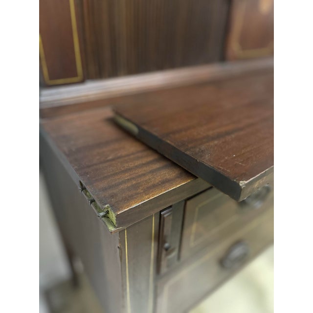 Features inlaid detailing, paneled doors, (unattached) fold-out desk top, and classic tapered legs. Upper cabinet provides...