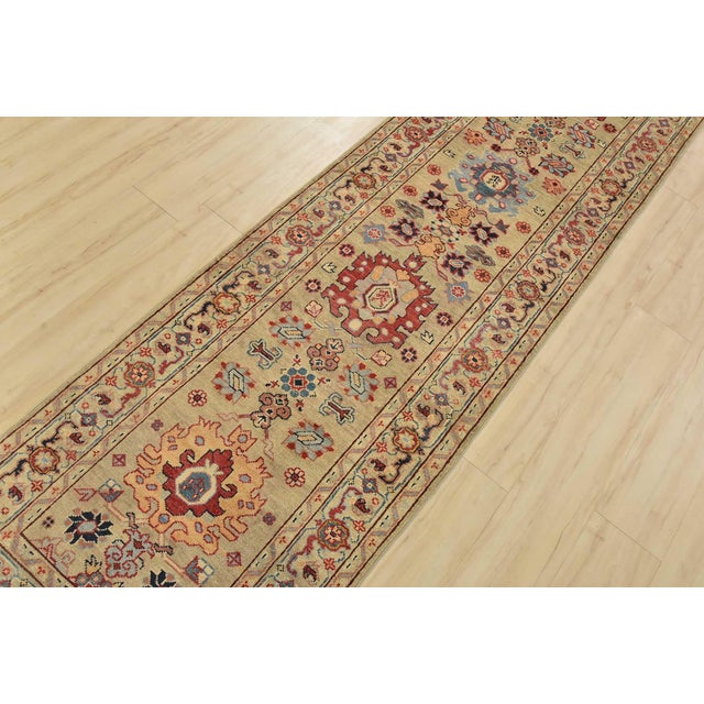 A traditional tribal Caucasian Kazak runner hand-knotted with fine wool on a cotton foundation. This rug features a row of...