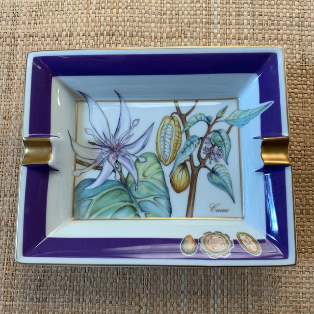 Hermes France porcelain ashtray. Features the cacao plant with greens and purple. 24k gold detailing. New condition.