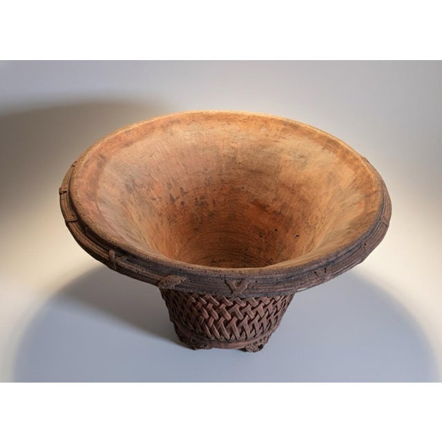 This striking earthenware vessel captures the primal elegance of ancient pottery traditions. Hand-built from rich,...