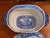 A blue and white transferware soup tureen with its lid. Country scenes all around — a thatched cottage on the body, a...