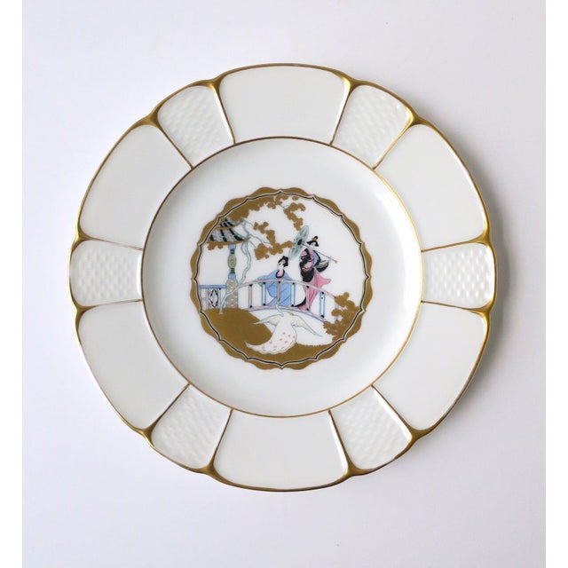 A beautiful German hand‑painted white and gold porcelain plate, “Rhododendron,” with an Asian figural scene featuring two...