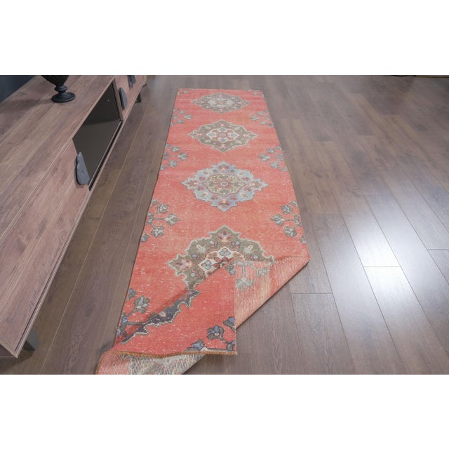 Add warmth, history, and character to your home with this beautiful vintage hand-knotted runner rug. Featuring a striking...