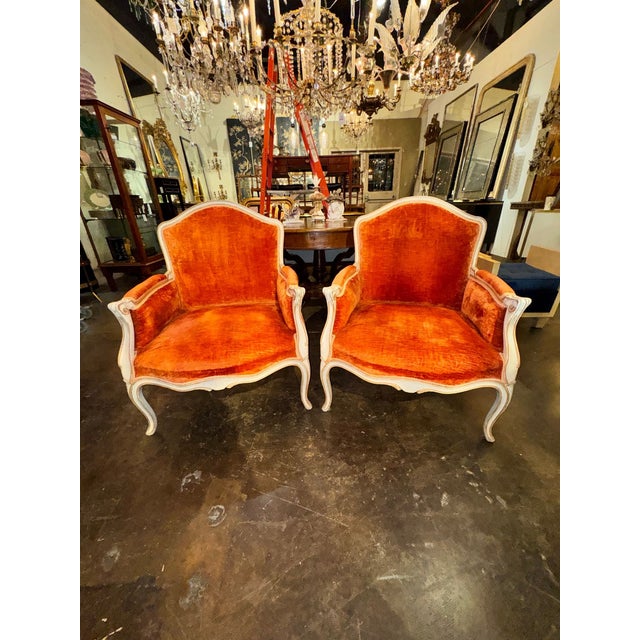 The product is a pair of large vintage French Louis XV painted bergere chairs. These chairs are elegant and luxurious,...