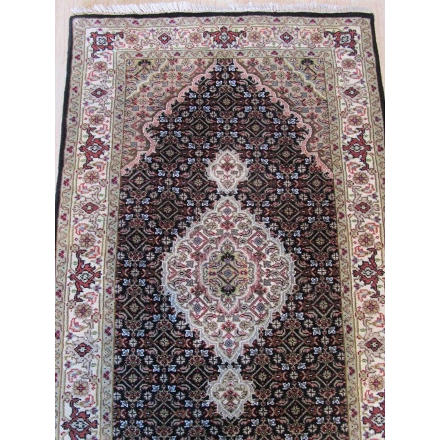 This brown earth tone wool rug features a hand knotted pile weave typical of classic Agra rugs. It is a genuine hand...