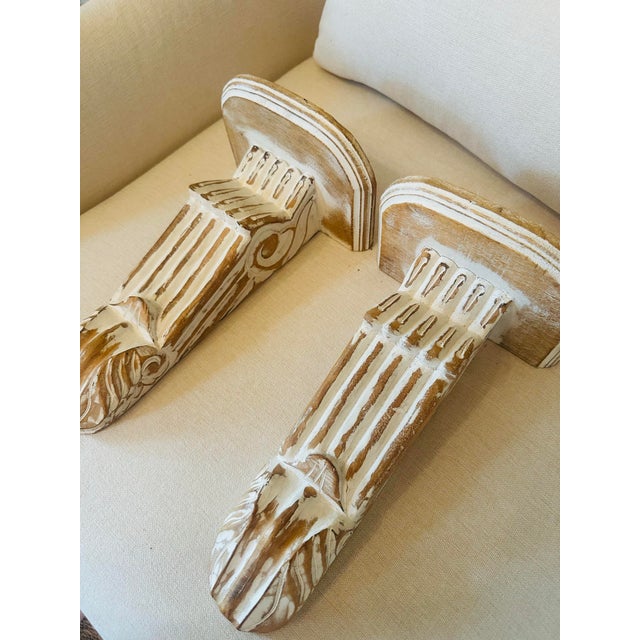 This charming pair of carved wooden wall brackets features a classical Ionic column design with hand-carved scroll details...