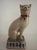 This vintage Staffordshire style cat figurine features a charming design with a red bow and a wry smile, adding a...