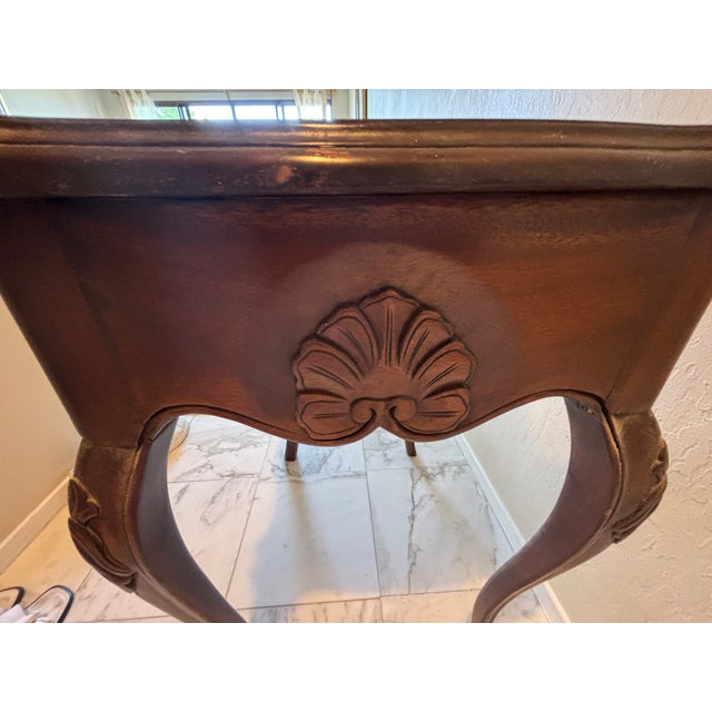 Vintage French Provincial accent table, solid wood with a warm mahogany-tone finish. Serpentine scalloped top, graceful...