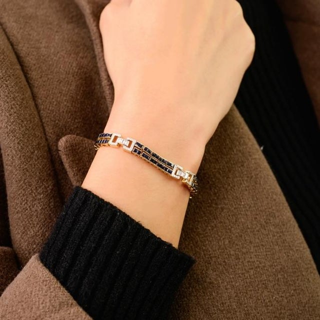 This elegant link bracelet blue features square cut blue sapphires totaling 6.14 carats, set in solid 14K yellow gold. The...