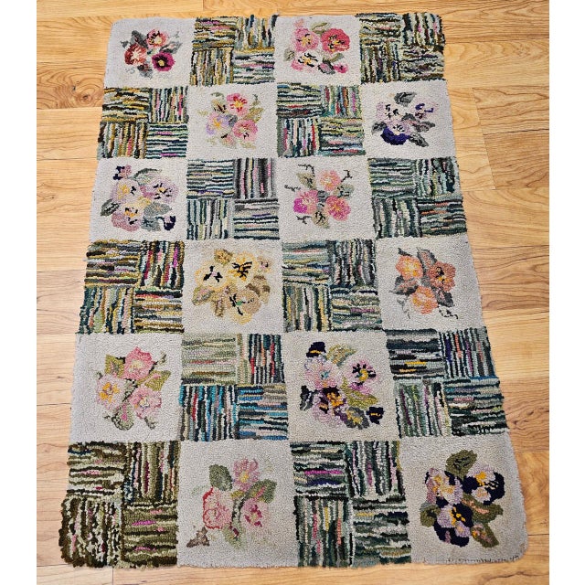 This early 20th century vintage American hand-hooked rug is a captivating example of traditional Americana folk art,...