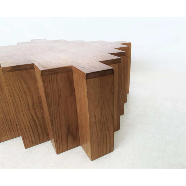 Modern sculptural coffee table. The strong geometric cube shaped with repetitive symmetrical setback corners is...