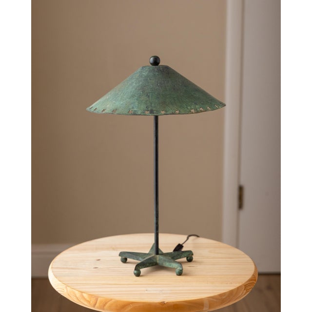 Vintage sculptural table lamp featuring a five-point star base with ball feet and a conical metal shade detailed with...