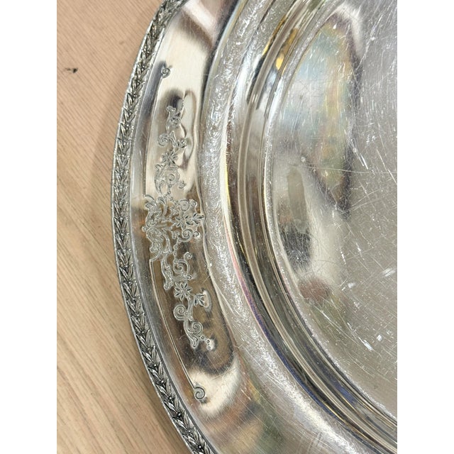 Lovely vintage silverplate tray. Made by International silver company. Features a floral design on the rim. Shows some...