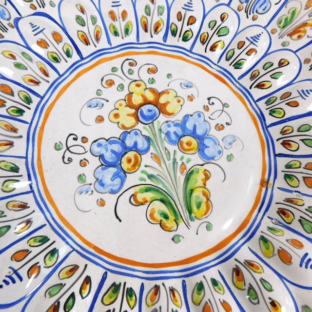 This is a large blue and white plate with a floral design done in blue, yellow and green with some red. It is marked Conde...