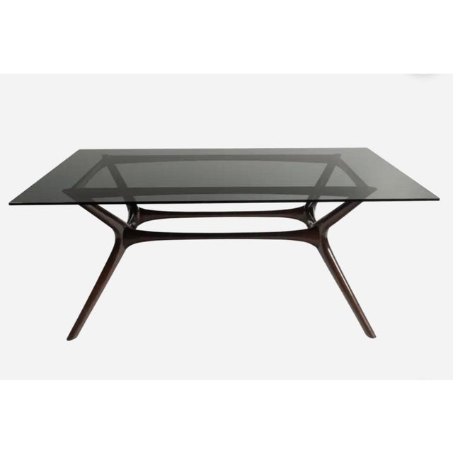 Mid-Century Modern style is beautifully expressed in the clean lines and sleek silhouette of this elegant dining table....