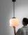 A glass and metal pendant lamp from Czechia, produced during the 20th Century. Descending from the ceiling upon a three...