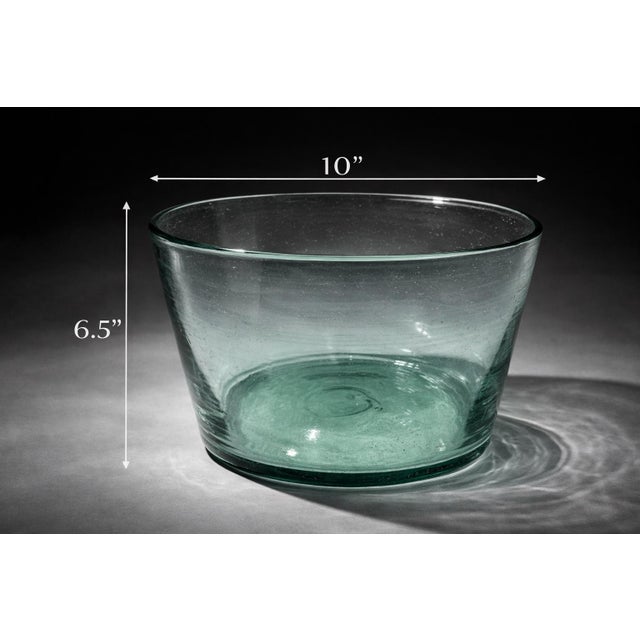 Beautiful handcrafted artisan glass bowl with a soft aqua-green tint and thick rolled rim. Hand-blown construction gives...