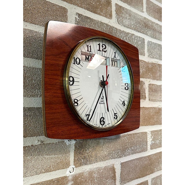 Rare vintage wall clock produced by the historic French company JAZ, featuring a rectangular case with a wood-effect...