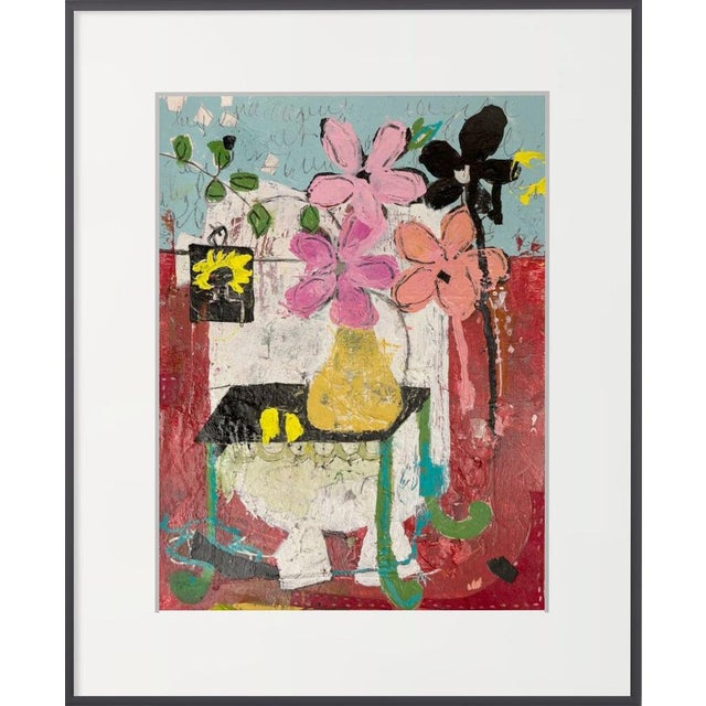 Pink and coral flowers and a pair of black blooms rise from a yellow vase on a small black table, set against a rich red...