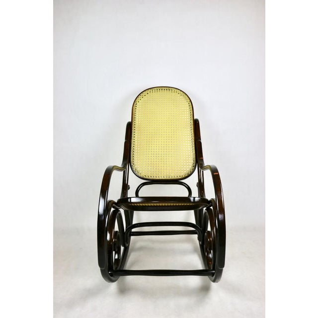 Rocking chair, 1980s. Original, in perfect condition. Wood elements re-lacquered in brown. This piece is attributed to the...