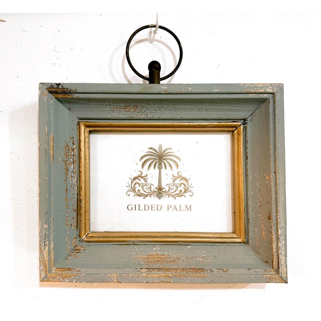 A distinctive pair of wall-hanging picture frames in distressed grey wood with stepped profiles, warm gilt inner...