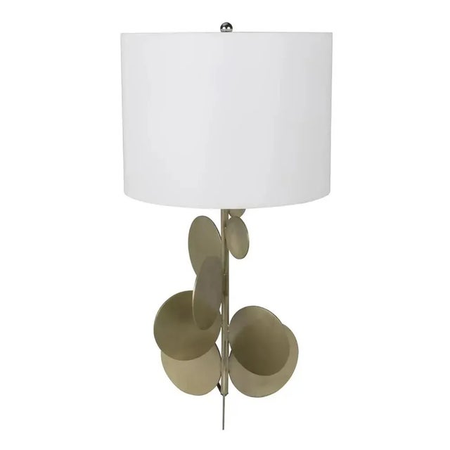 Petal like accents in metal adorn the base of this decorative, handcrafted table lamp. A coordinating finial and shade are...