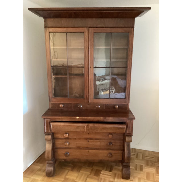 The desk, drawers and glass doors are framed in cherry wood with a flourish of dark tones of black smattered about the...