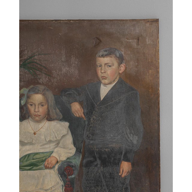 This early 20th-century French portrait painting captures a tender domestic moment, depicting two children in formal...
