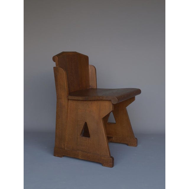 A solid oak side chair in the Dutch traditionalist or Neo-Gothic manner. The chair has a very ordered appearance and...