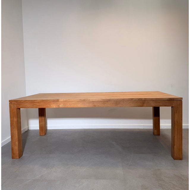 Beautiful large dining table crafted from solid teak, featuring a clean architectural design with thick square legs and a...