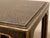 A handsome vintage side table with a richly textured black surface and warm antiqued gold detailing. The tabletop has a...