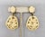 Early 1970s goldtone and ivory colored Lucite flower drop clip back earrings. Marked crown "Trifari" with a copyright....
