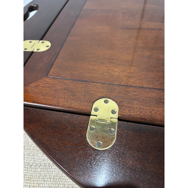 Butler’s tray table made by Baker. This style features a removable tray top with handles and decorative brass hardware ,...