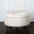 Bench-made in the USA, this ottoman features deep button tufting and a plush, dotted faux ostrich leather upholstery in...