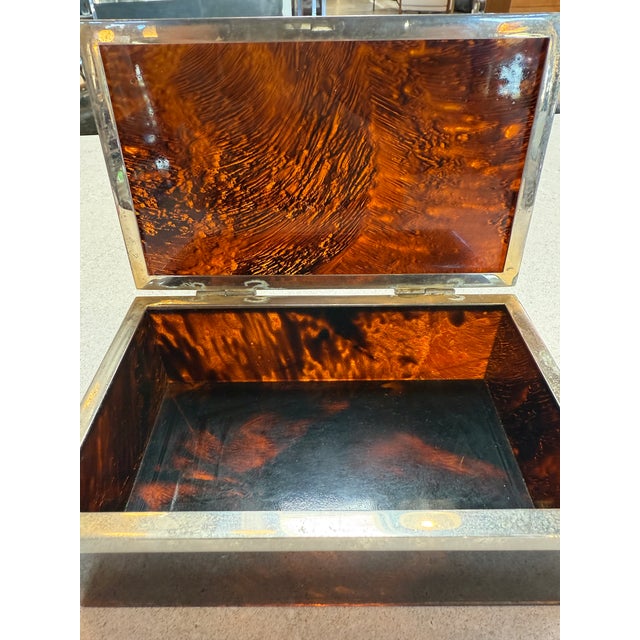 Elegant vintage box crafted in Italy in the 1970s, featuring richly patterned faux tortoiseshell panels framed by a brass...