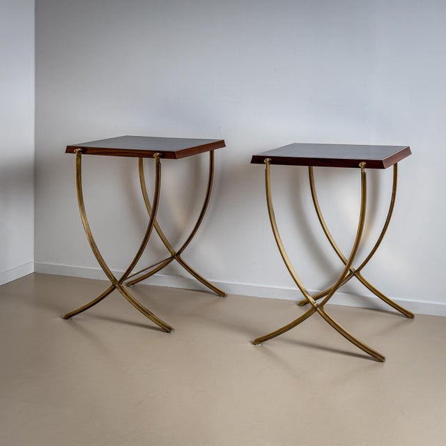 Two side tables by Luigi Caccia Dominioni on crossed, curved legs made of polished brass and rectangular wooden tops with...