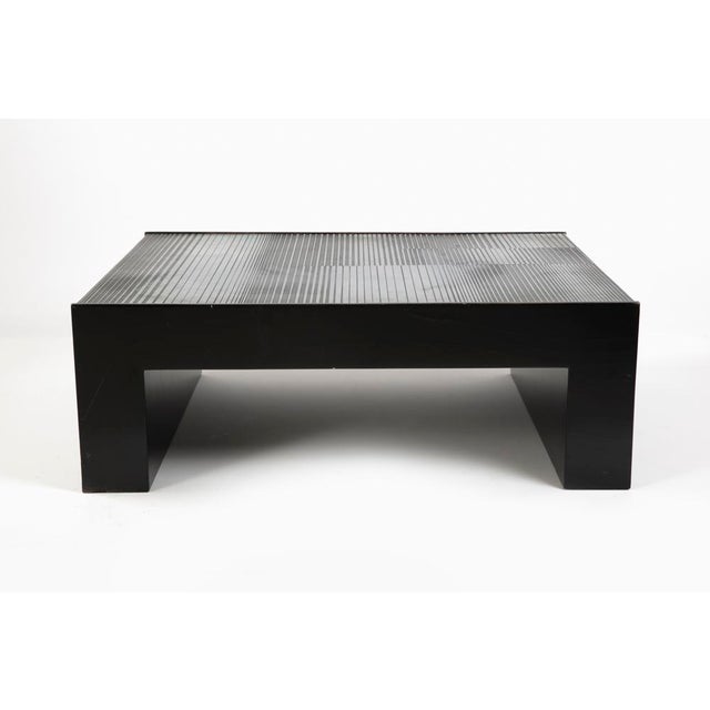 coffee table with lacquered wood structure and acid-treated aluminum sheets to create a surface decorated in relief....