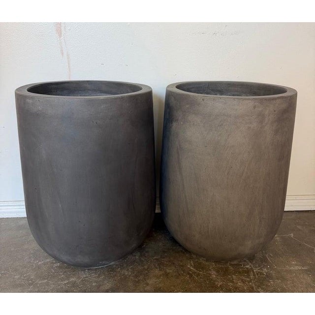 A striking and highly architectural pair of monumental tall cylinder planters, embodying pure, modern minimalism and quiet...