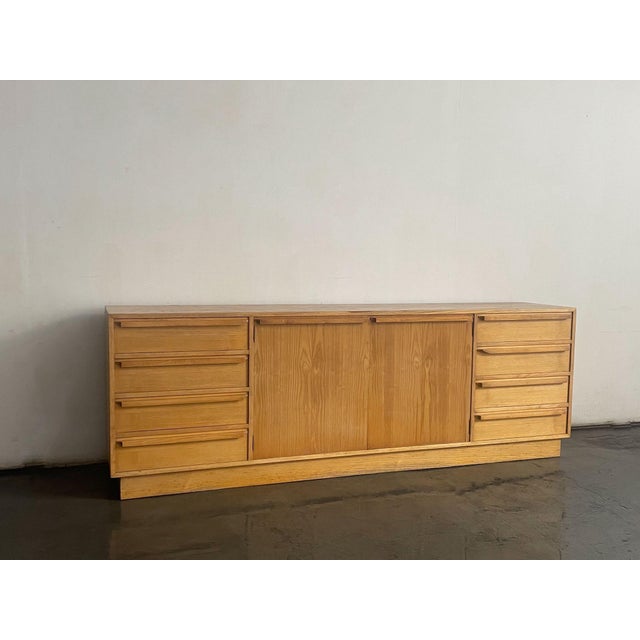 A masterclass in organic modernism, this expansive 1970s Spanish credenza utilizes highly active pine veneer to deliver...