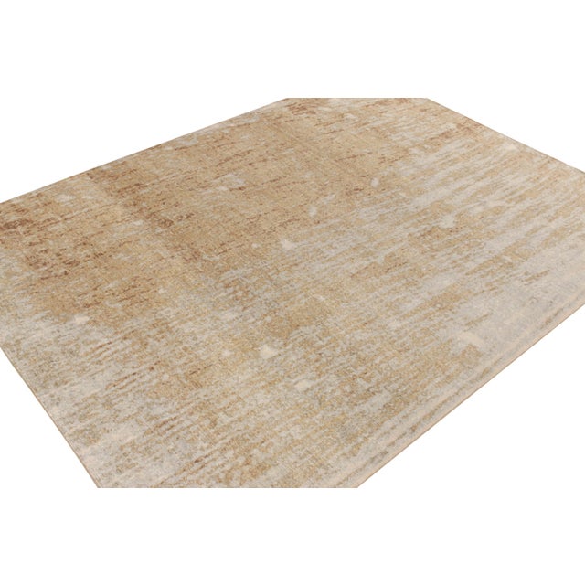 From Rug & Kilim’s Homage collection, a 9x12 distressed style piece in comforting beige-brown, white and blue painterly...