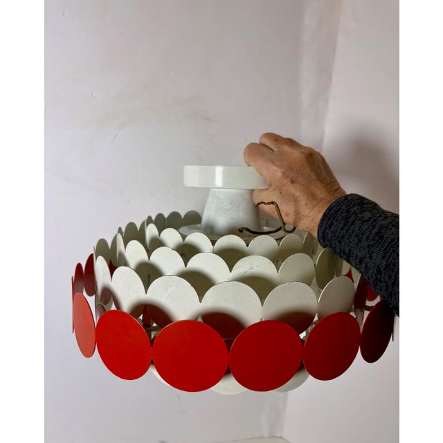 Our mid-century modern, semi-flush fixture is a statement piece featuring seven rings, with white round discs and an outer...