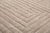 Layer upon layer of concentric lines nest inward across this light taupe rug, drawing the eye steadily toward its quiet...