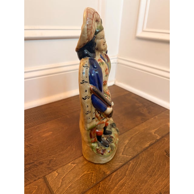 Heavy ceramic male figure in Scottish attire with dog and gun.