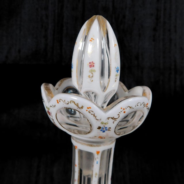 This is a white over clear cut to clear glass perfume bottle with a lot of tiny flowers in in blue, pink and orange with...