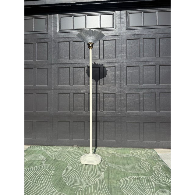 A sculptural torchiere floor lamp from the late 1970s featuring a dramatic clear ribbed plastic shade that fans outward...