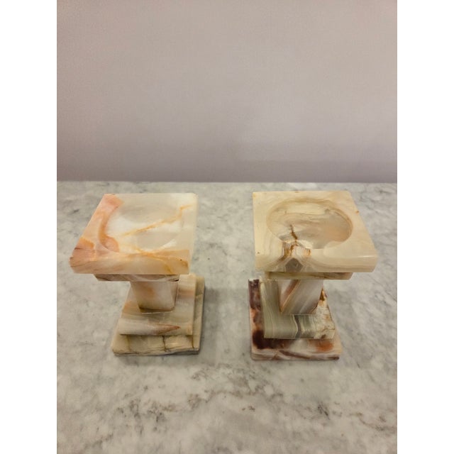A striking pair of vintage carved stone stone candle holders featuring beautiful natural veining in warm cream, honey,...