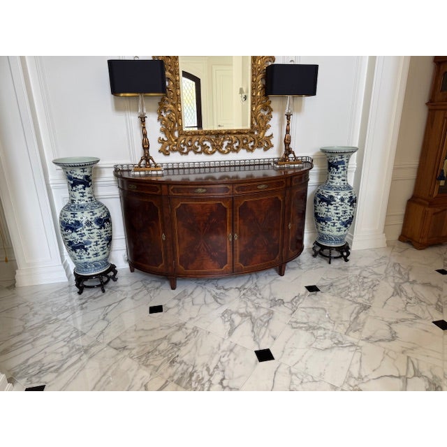 Large blue and white vases (or urns) make a statement in any room. The vases are elevated on wooden stands.